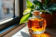 © Thanyarat - A honey-colored glass bottle on a windowsill, with the sunlight casting warm, amber reflections in the room