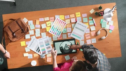 Wall Mural - Top view of smart designer holding color palette while project manager looking at design and choosing color for program. Professional businesswoman taking a note while design creative logo. Symposium.