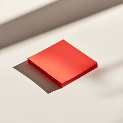 Poster - A red sticky note holder lying flat at the center of a light colored surface isolated and minimalist in design