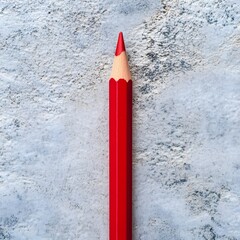 Poster - A close up photograph of a single red pencil placed at the center of a plain minimalist surface  The pencil is the focal point showcasing its vibrant color and simple