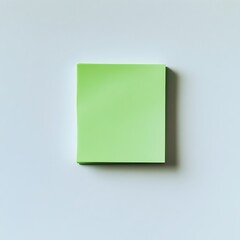Poster - Close up of a green sticky note pad placed at the center of a clean white workspace surface  The minimal simple design creates a professional and organized look perfect for business office