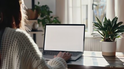 Poster - Focused young woman working on a laptop with a blank copy space screen, ideal for mock-up designs and digital workspace concepts, featuring a modern home office setting with a clean desk and minimalis