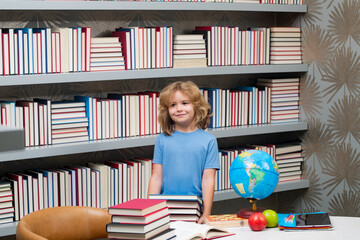 Fototapete - School boy with stack of books in library. School and kids. Cute blonde child with a book learning. Knowledge day.