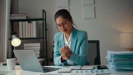 Poster - Businesswoman experiencing wrist pain. A young asian accountant woman is feeling pain in her wrist, possibly due to prolonged computer work or repetitive motions