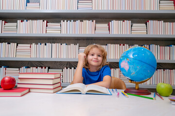 Fototapete - School and students in classroom. Education kids. Child pupil student in the school class. Studying and learning concept. School boy in the library near school supplies. Kid learn geography with globe