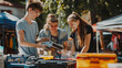 © MikeLegend - Smiling teenagers setting up a garage sale in the sunshine