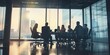 © xartproduction - Silhouettes of professionals engaged in a business meeting in a modern boardroom at sunset