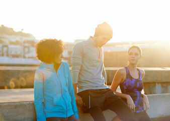 Canvas Print - Friends, thinking and rest in city for fitness, exercise and running session for marathon challenge outdoor. Bridge, man and women by sunshine for wellness goals, jog break and bonding together