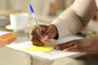 © PheelingsMedia - Black man hand writing on sticky note