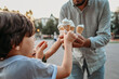 © Westend61 - Father giving ice cream cones to sons