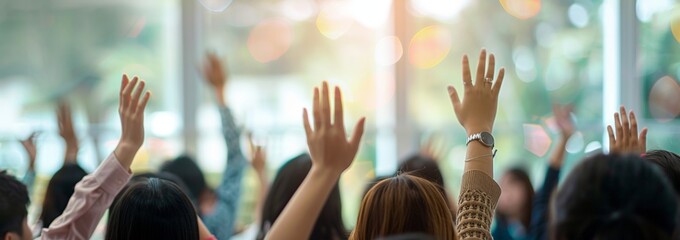 A group of people are in a classroom, one of them raising their hand