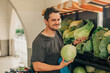 © Westend61 - Smiling man holding cabbages at vegetable stall