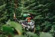 © Westend61 - Woman gesturing and exploring trees through VR headset