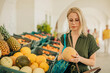 © Westend61 - Woman examining melon at fruit stall