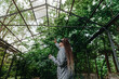 © Westend61 - Woman watching trees through VR glasses in greenhouse