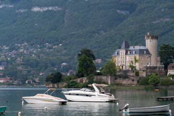 A small boat is docked next to a large boat, Annecy lake