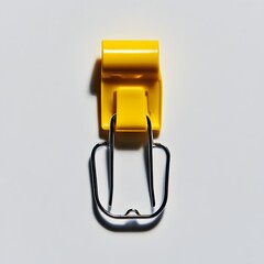 Poster - A close up photograph of a single yellow metal binder clip placed at the center of a plain light colored surface  The clip has a simple modern and minimalist design