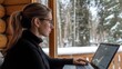 © Kenny - Woman Working on Laptop in Snowy Cabin - Remote Work and Winter Serenity