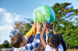 © Rido - Children holding earth model for sustainable living concept
