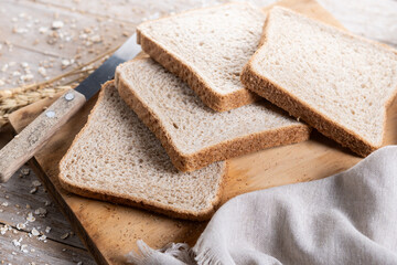 Healthy wholemeal bread slices on rustic wooden table