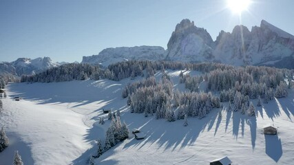 Sticker - 4k drone flight moving to the side footage (Ultra High Definition) of  Alpe di Siusi village with Plattkofel peak on background. Sunny morning view of Dolomite Alps. Cold winter scene of Ityaly.