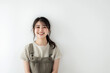© Logmotion - オーバーオールを着た笑顔のアジア人女性のスタジオ撮影