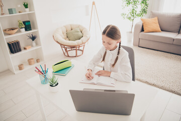 Wall Mural - Photo of lovely little girl write notebook study online laptop desk modern flat indoors