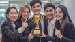 © Mikki Orso - Celebrating success  happy team of workers in office holding a golden trophy for project achievement