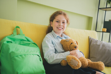 Canvas Print - Photo of charming cute adorable small girl sitting sofa hold her best friend soft toy teddy bear room apartment indoors