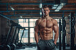 © Alina - Young muscular man posing in the gym center