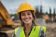 © antusher - Smiling female construction worker with hard hat, high-visibility vest, daytime site