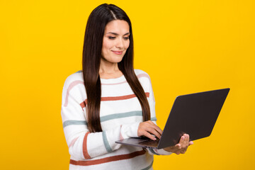 Wall Mural - Photo of mature brunette hair business lady using laptop computer during work session isolated on yellow color background