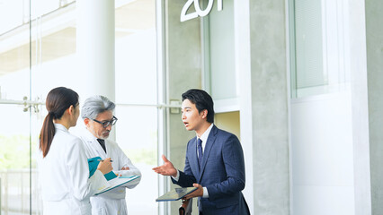 Poster - ビジネスマンから説明を受ける白衣の医師・研究者