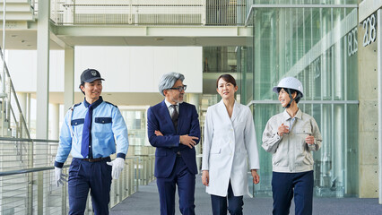 Fototapete - ロビーを歩く様々な職業の人々（ビジネスマン・エンジニア・研究者・警備員）