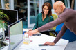 © sepy - Businesswoman and businessman sitting at the office in front of computers and having business meeting