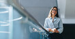 © Jacob Lund - Empowered female professional smiling as she stands in an office