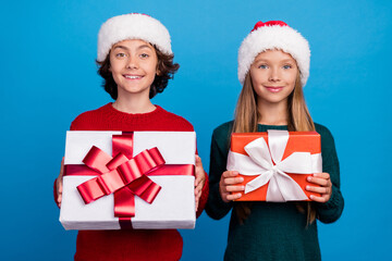 Poster - Photo of two people kids hold showing gift box christmas isolated blue color background