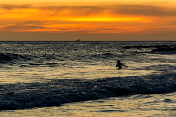 Bathers are seen having fun during sunset on Farol da Barra beach in the city of Salvador, Bahia.