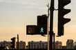 © yaqui_villegas - The image shows a traffic signal with a green pedestrian light in an urban environment during sunset, highlighting transportation and city life dynamics.