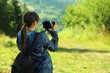 © New Africa - Photographer with backpack and camera taking picture outdoors, back view. Space for text