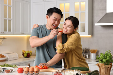 Wall Mural - Happy lovely couple cooking together in kitchen