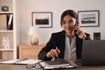 Sticker - Beautiful businesswoman talking on smartphone at table in office