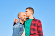 © ADDICTIVE STOCK - Gay couple enjoying a loving moment under a clear blue sky