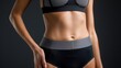 © ProPhotos - A close up of a girl's slim, toned stomach in a bikini showing off her flat belly and strong, defined abs, demonstrating athleticism and a toned body.