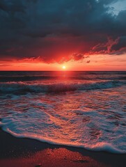 Canvas Print - A fiery sunset casts warm hues over a tranquil ocean scene. The sun dips below the horizon, painting the sky with vibrant orange and red tones.