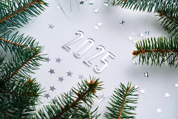 Wall Mural - abstract light christmas background with stars and a christmas tree with the year number 2025.