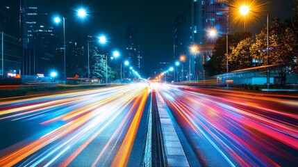 Fototapete - A vibrant city street illuminated by streetlights at night, with light trails from passing cars creating a dynamic and lively scene.