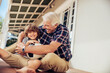 © Marko Geber - Grandfather and grandson playing with soccer ball on home porch