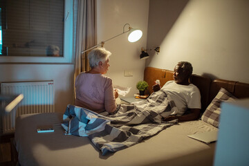 Wall Mural - Senior couple reading medication instructions in bed