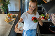 © Geber86 - Smiling young woman using smartphone in modern kitchen